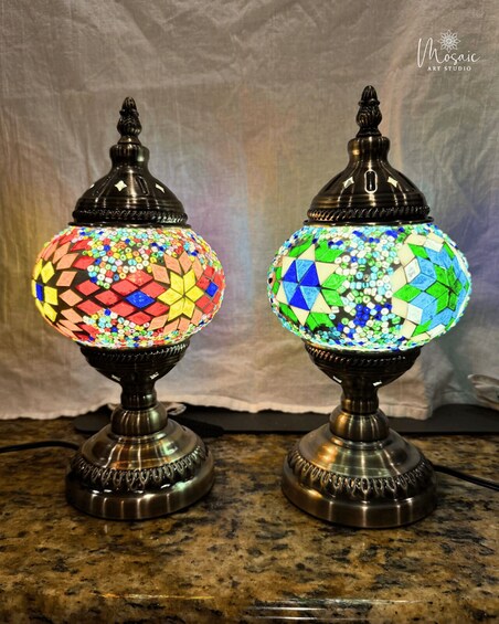Two mosaic lamps with metal bases on a countertop. 5
