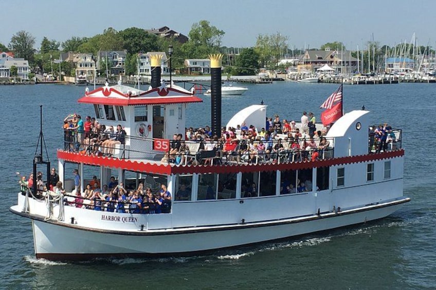 A white boat with red accents named 'Harbor Queen' on a body of water. 4