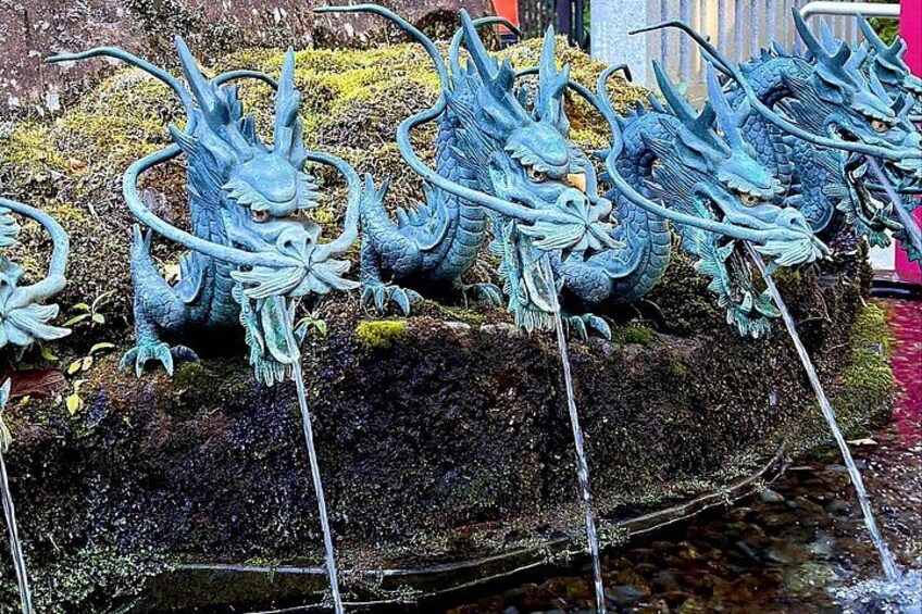 En række dragefigurer på en mosbegroet sten ved en å. 3