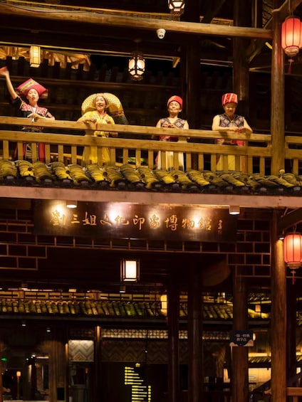 A traditional wooden structure with people in cultural attire. 2