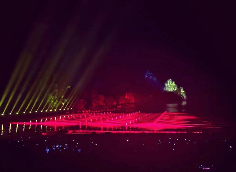 A concert with laser lights and a crowd. 4