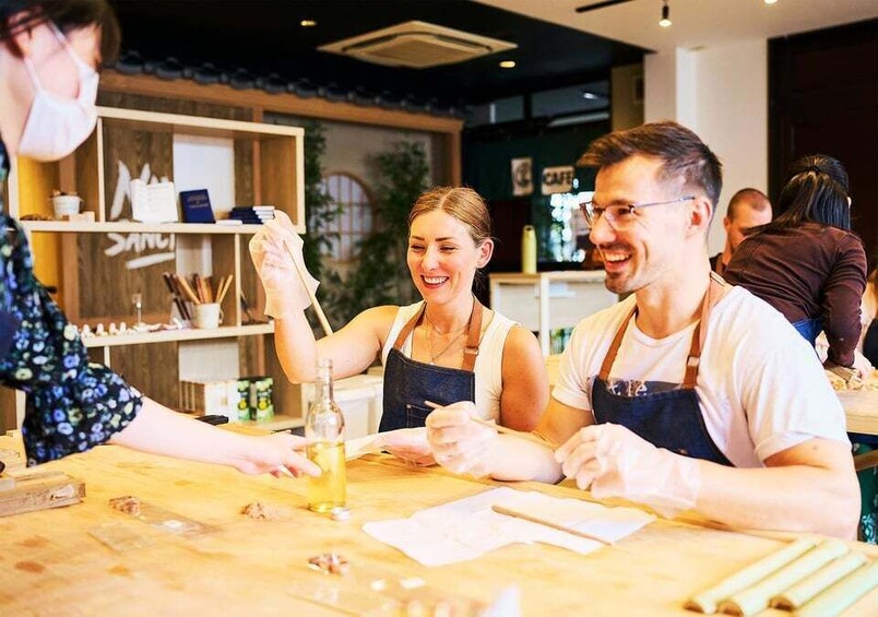 A person holding a bottle, a table with papers, and a shelf with items in a cafe setting. 1