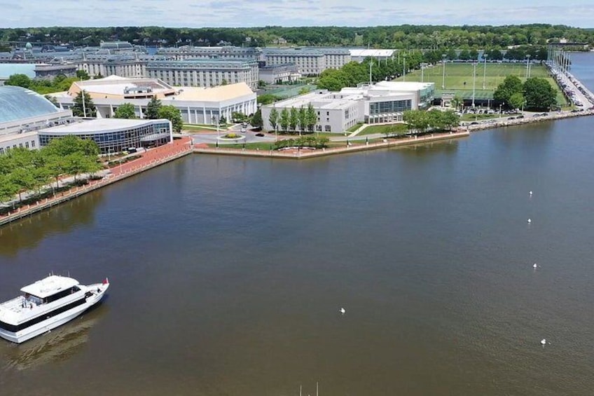 A river with a boat, buildings, and a bridge. 3