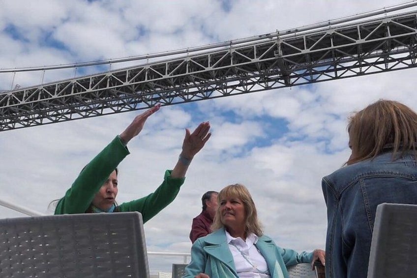 A group of people outdoors with a metal structure overhead. 2