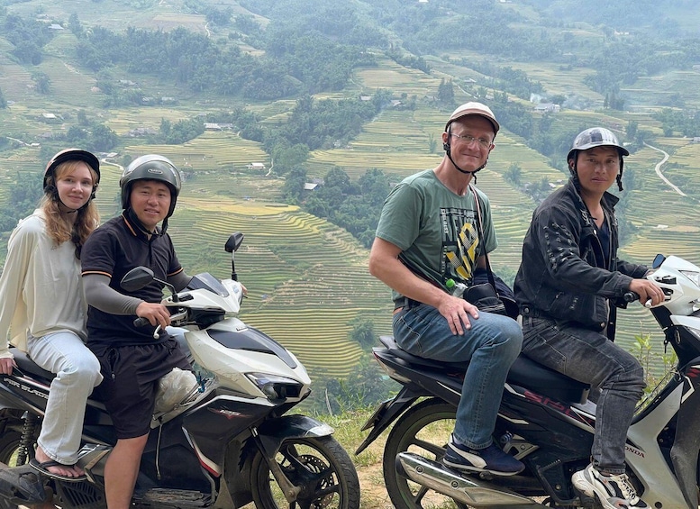 Four people on motorcycles with terraced fields in the background. 1