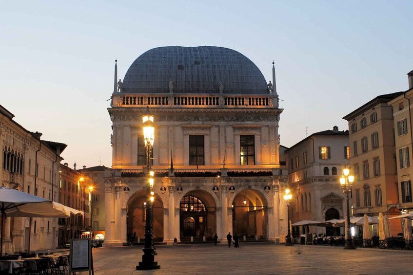 A historic building with a dome and arches, surrounded by other buildings and outdoor seating. 4