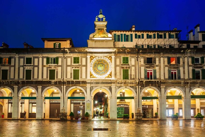 A historic building with a large clock and arched entrances. 2