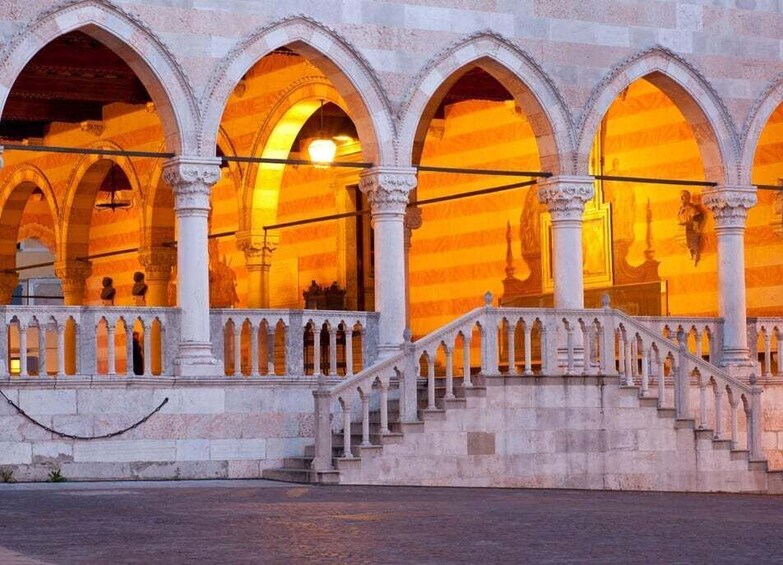 A historic building with arched windows and a staircase. 3