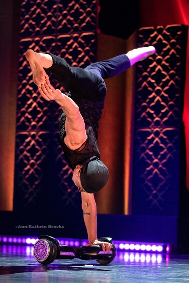 A person performing a handstand on a hoverboard. 5