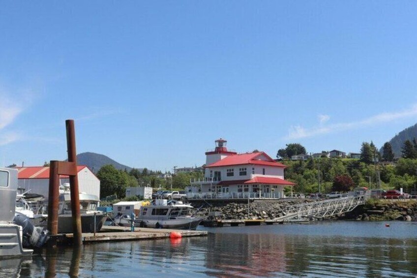 A marina with boats, a red-roofed building, and a mountain in the background. 4