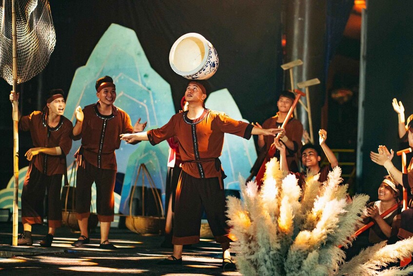 A group of people performing a traditional dance with a large bowl on their heads. 4