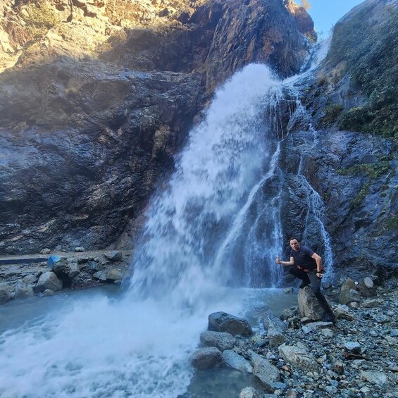 A waterfall cascading down a rocky cliff into a pool of water surrounded by rugged terrain. 3