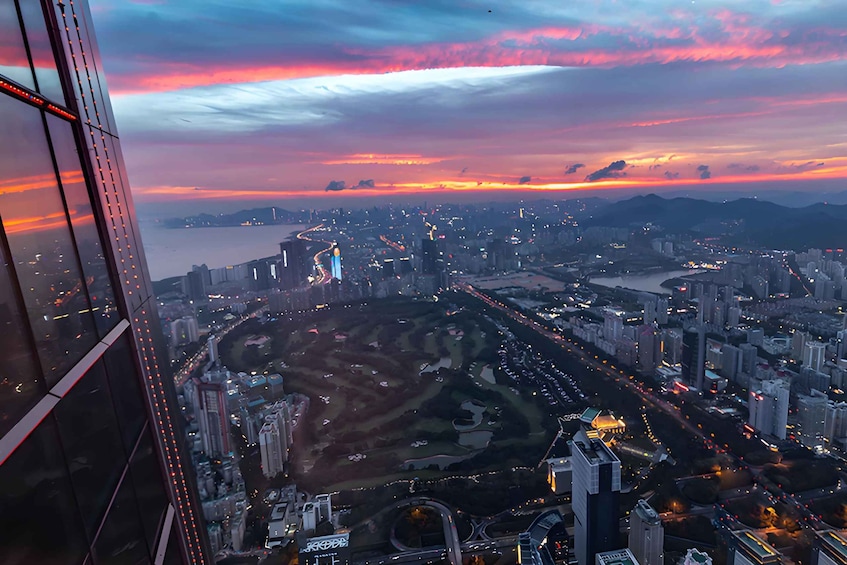 A cityscape at sunset with a river, roads, and buildings. 3