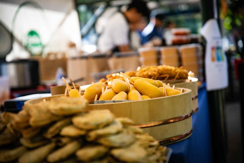 A food stall with a variety of fried snacks and a person in the background. 3