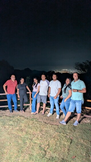 A group of people standing on a grassy area with a city skyline in the background. 3