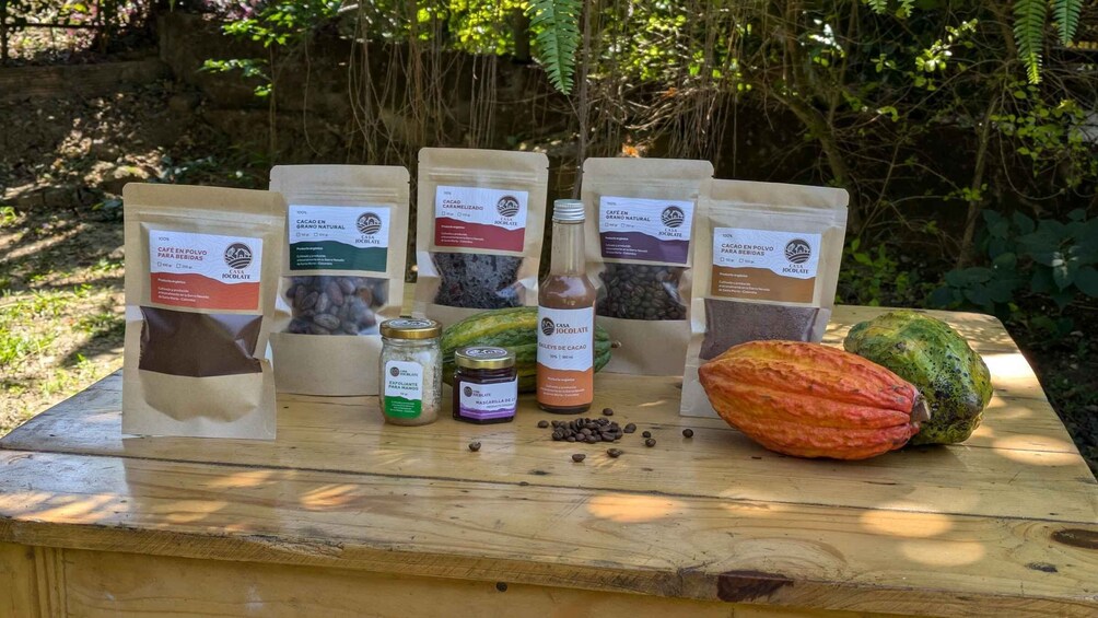 A wooden table with various cocoa products, including bags of cocoa powder, a jar of cocoa butter, and a bottle of cocoa extract. 2