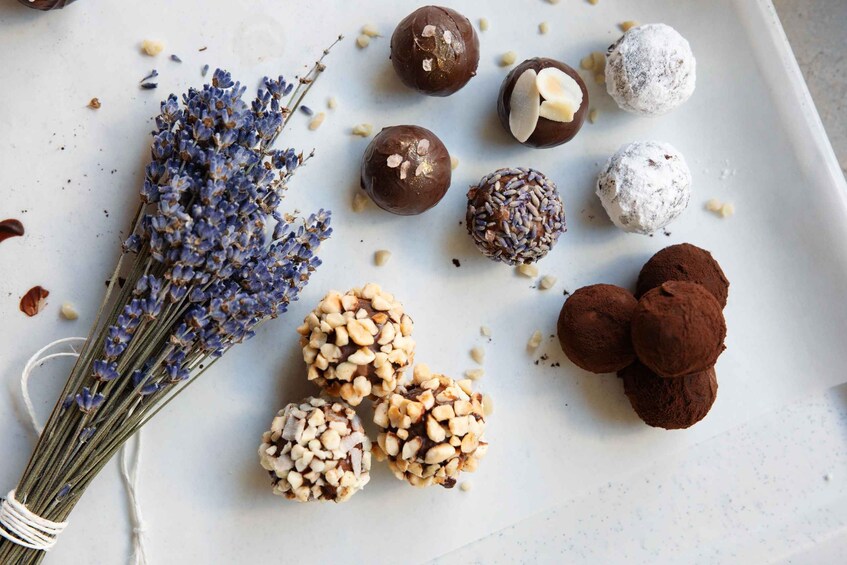 A variety of chocolate truffles and nuts on a baking sheet. 4
