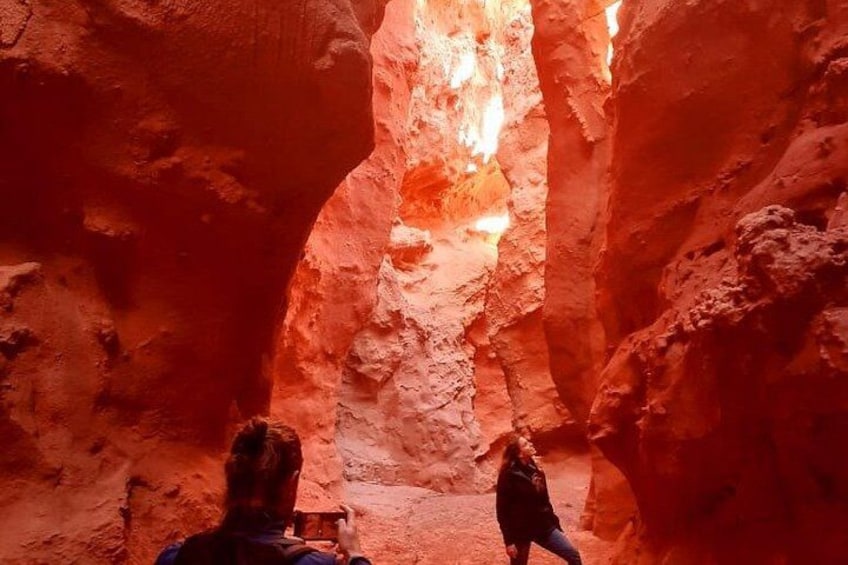 A canyon with red rock walls and a person standing in the middle. 5