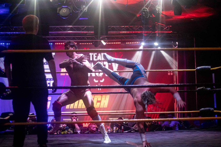A boxing match in a ring with a crowd in the background. 4
