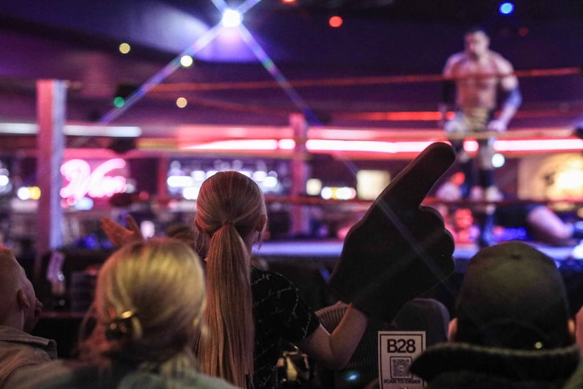 A person on stage with a microphone, a crowd facing them, and stage lighting. 5