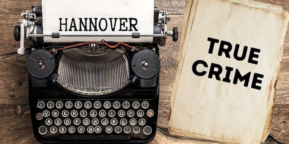 A typewriter with a sheet of paper that reads 'HANNOVER' and another paper with 'TRUE CRIME'. 1