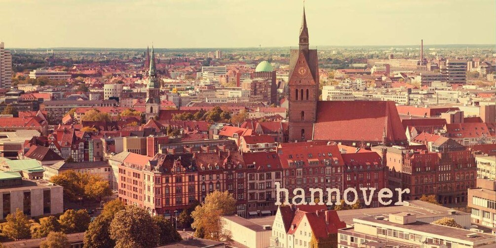 A cityscape with historic buildings, a prominent church tower, and the word 'hannover' overlaid. 3