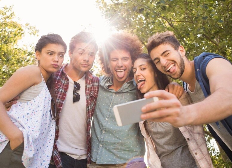 A group of people taking a selfie outdoors with trees in the background. 5