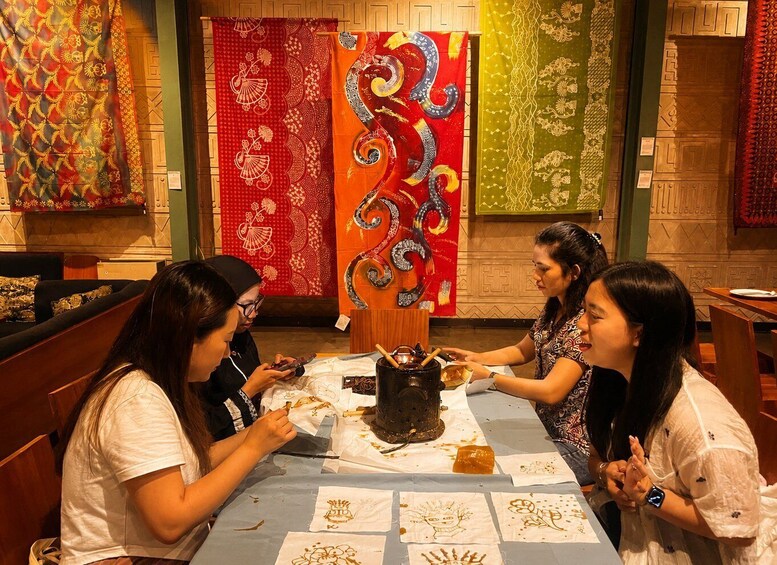A group of people sitting at a table with a traditional drink and food, surrounded by colorful tapestries. 5