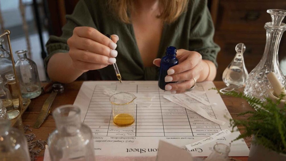 A person conducting a chemistry experiment with various glassware and a chart. 4