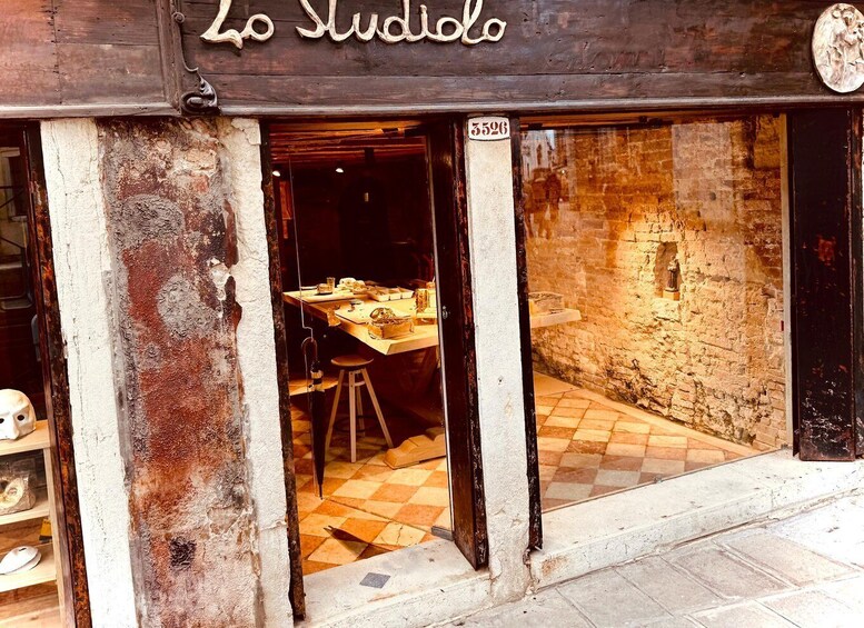 A rustic storefront with a wooden sign reading 'Lo Studio.' 1