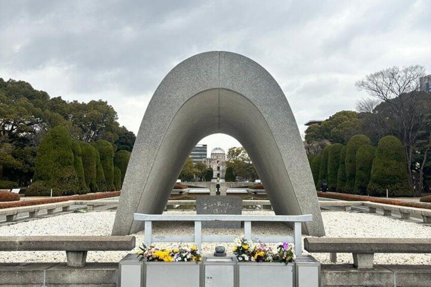 A memorial arch with a bench and flowers in front. 5