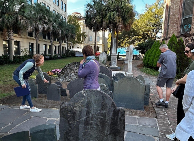 A cemetery with headstones, palm trees, and a building in the background. 3