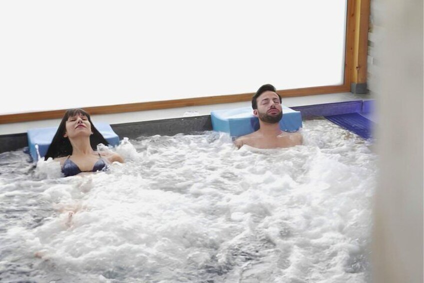 Two people in a hot tub with foam. 2