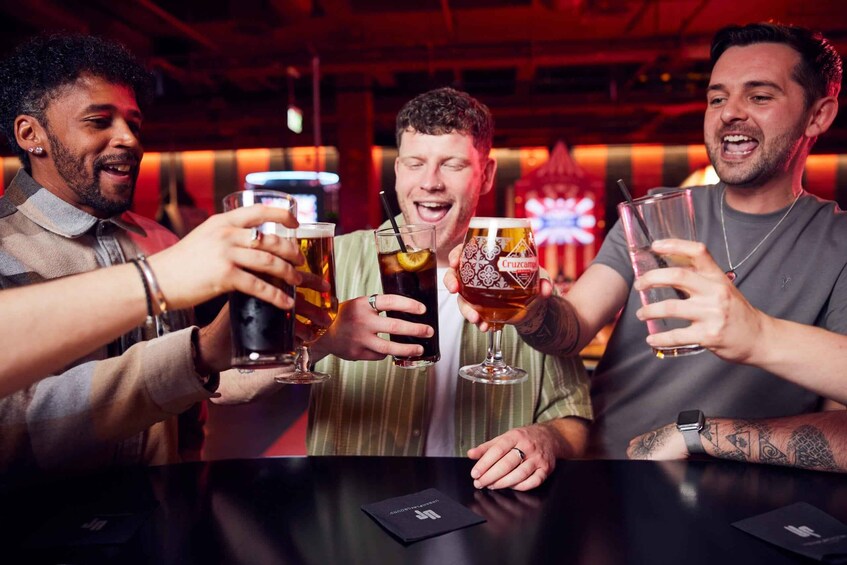Three people toasting with drinks at a bar. 4