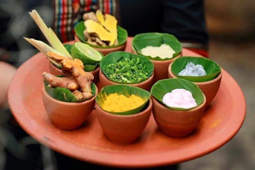 A tray with small clay cups containing various food items. 2