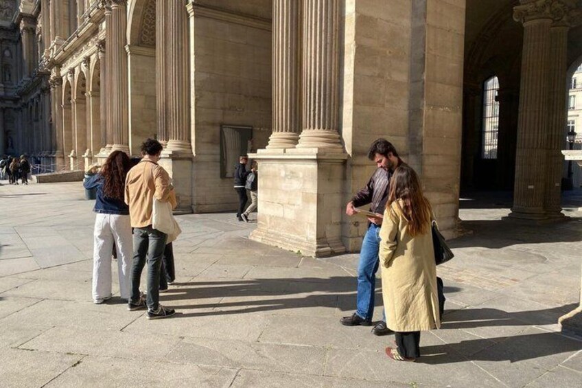 A group of people standing in front of a large classical building with columns. 2