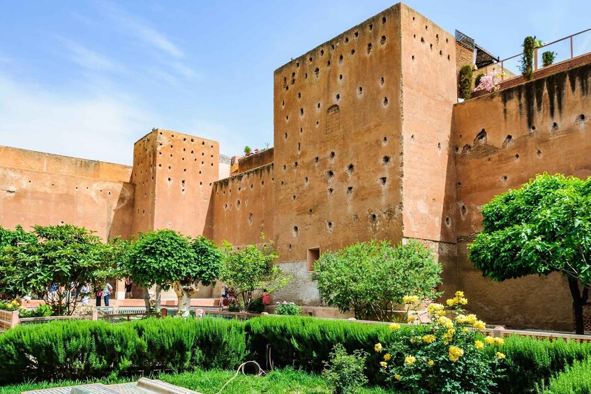 A historic fortress with crenellated walls and a lush garden. 5