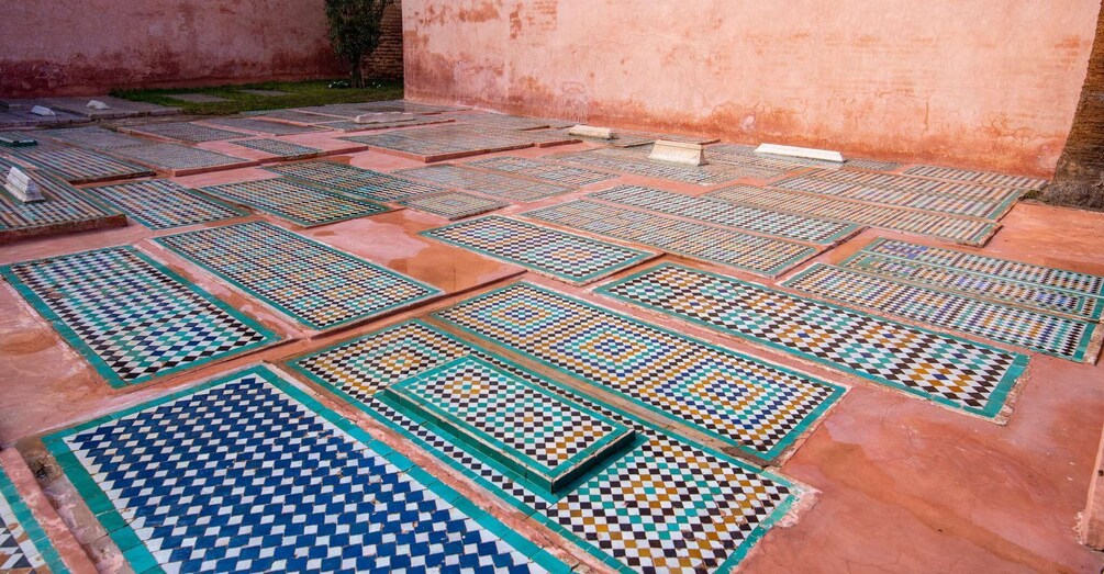 A courtyard with patterned tiles and a brick wall. 3