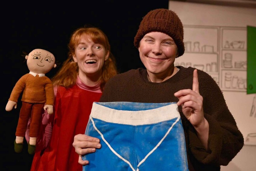 A person holding a puppet and a blue garment. 2