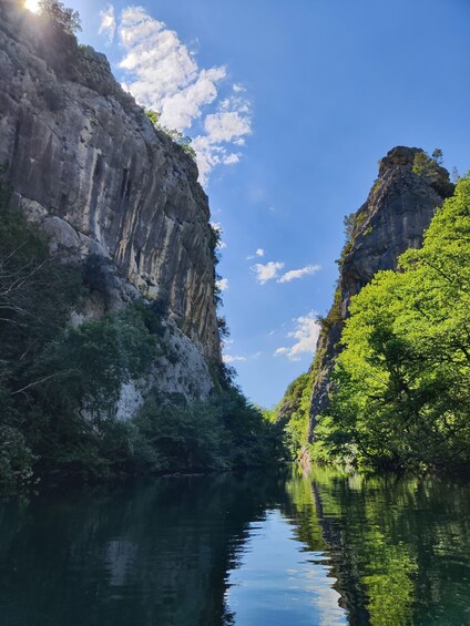 A river canyon with steep cliffs and dense green foliage. 5