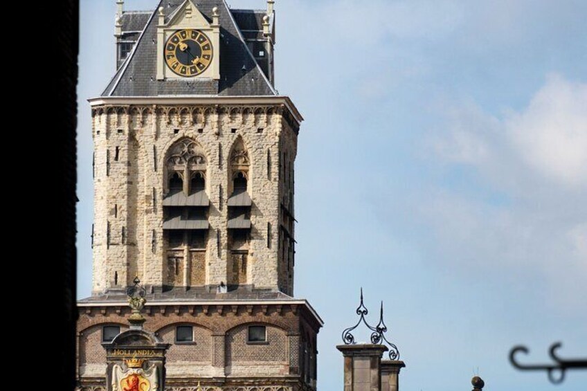 A historic clock tower with a large clock face, intricate architectural details, and a weather vane. 5