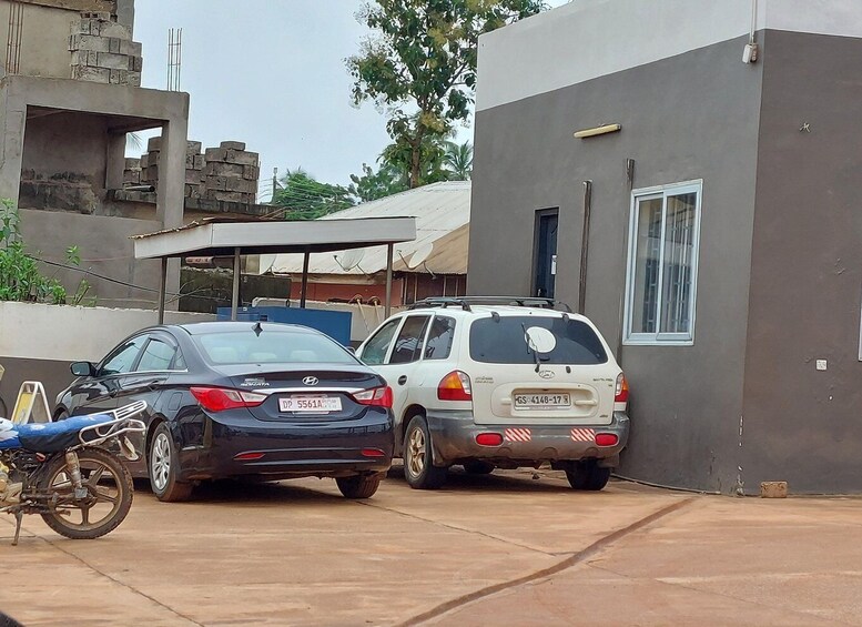 Two cars parked in a driveway, a motorcycle, and a building under construction. 2
