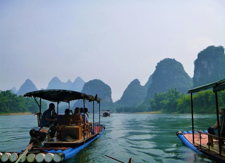 A river with boats, passengers, and limestone karst formations in the background. 5