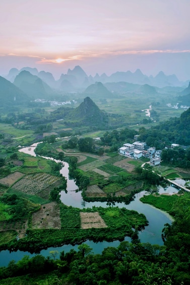 A river winding through terraced fields, surrounded by lush greenery and distant mountains. 4