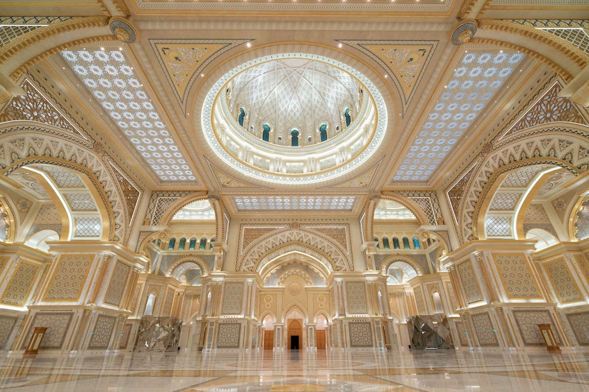 An ornate interior with a large central dome, intricate ceiling patterns, and detailed wall decorations. 1