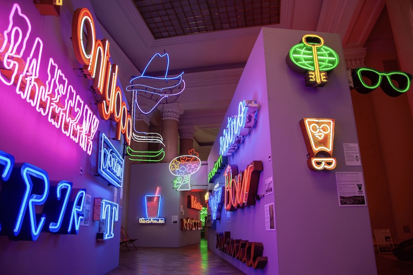 A hallway with colorful neon signs and sculptures. 4