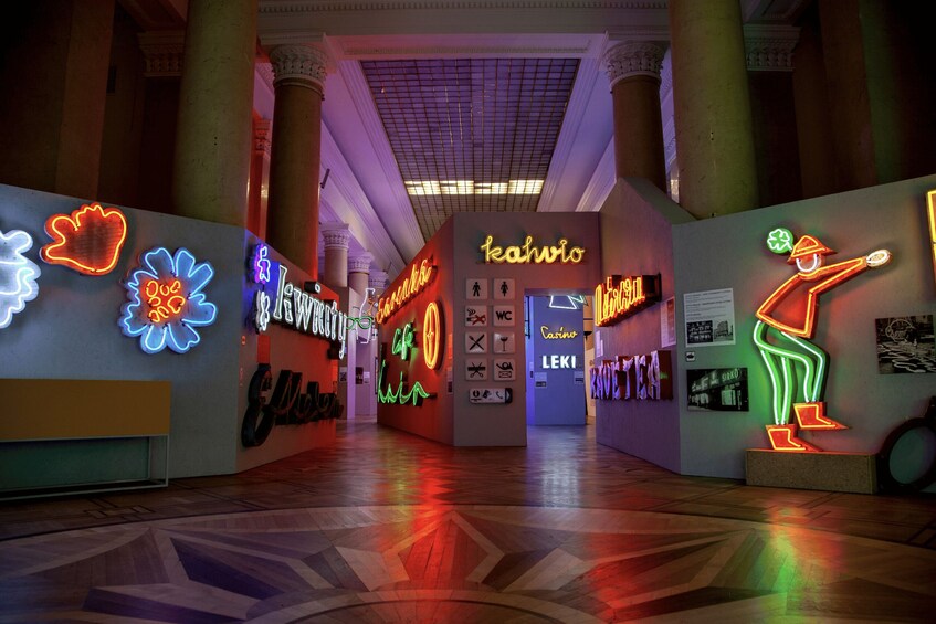 A brightly lit corridor with neon signs and a patterned floor. 5