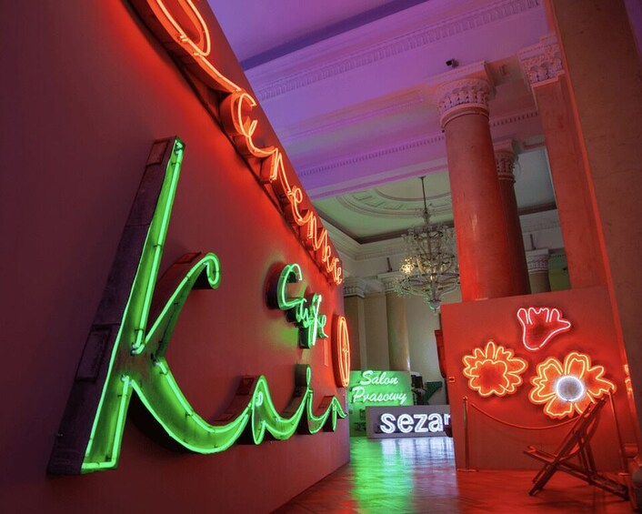 A neon sign with the word 'Kleingarten' in green and red, a chandelier, and a flower-shaped neon sign. 3