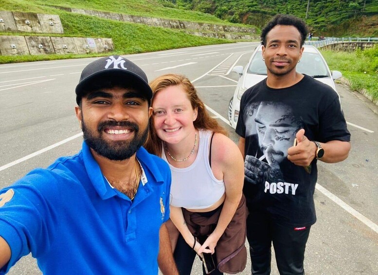 Three people taking a selfie on a road with a car in the background. 3