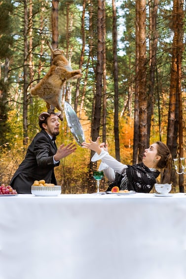 A forest with tall trees and a table set for a meal. 5